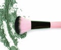 Makeup brush with green crushed eye shadow, isolated on white macro. Royalty Free Stock Photo