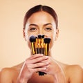 Makeup, brush and portrait of woman with cosmetic beauty product for skincare isolated in a studio brown background