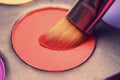 Makeup brush on red shadows. Bright shadows for the summer. Macro frame of shadows. Bright cosmetics, fashionable colors Royalty Free Stock Photo