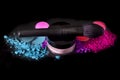 Makeup brushes and colorful eyeshadows on a black background, top view. colorful crushed eyeshadow powder