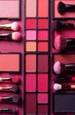 Makeup brushes and eyeshadow palettes creating a captivating flat lay on pink background Royalty Free Stock Photo