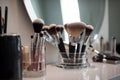 Makeup brushes in a glass. Clean professional makeup brushes set for make-up artist, cosmetics, make up theme. AI generated