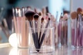 Makeup brushes in a glass. Clean professional makeup brushes set for make-up artist, cosmetics, make up theme. AI generated