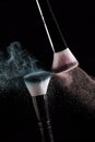 Makeup brushes with red and green powder explode on a black back Royalty Free Stock Photo