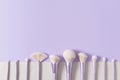 Makeup brushes set in row. Professional makeup tools on violet background. Set of glamour make up brushes. Magazines, social media Royalty Free Stock Photo