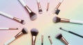 Makeup brushes and sparkling glitter arranged on a soft pastel gradient background Royalty Free Stock Photo