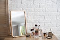 Makeup cosmetic products and tools on dressing table near brick wall Royalty Free Stock Photo