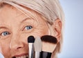 Makeup, cosmetics and face of a senior woman with brushes against a grey studio background. Happy, smile and portrait of Royalty Free Stock Photo
