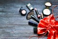 Makeup cosmetics in red bag on wooden background. Santa Claus gifts in a bag. Royalty Free Stock Photo