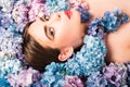 Makeup cosmetics and skincare. Nature beauty. Woman lying on flowers. Unity with nature. Blossom. Girl with hydrangea