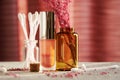 Makeup desk with jars, lipstick and cotton buds with scented pink petals Royalty Free Stock Photo