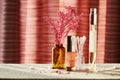 Makeup desk with tiny perfume jar, lip gloss, cotton buds and lilac branch Royalty Free Stock Photo