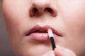 Makeup. Girl applying lipgloss lipstick on lips. Part of face. Royalty Free Stock Photo