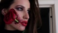 Makeup for Halloween, rose flower in mouth. Portrait of a girl holding a red rose in her mouth. Royalty Free Stock Photo