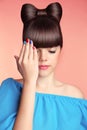 Makeup. Manicure. Beautiful teen girl with bow hairstyle and multicolor manicured polish nails. Funny girl showing fingers