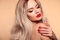 Makeup, manicured nails. Beauty portrait of blonde woman with red lips, long healthy shiny blond hair style. Sensual girl with Royalty Free Stock Photo