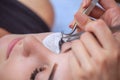 Makeup Master corrects, and strengthens eyelashes beams, holding out a pair of tweezers