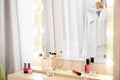 Makeup mirror on table near white wall in dressing room Royalty Free Stock Photo