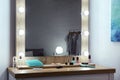 Makeup mirror on table near white wall Royalty Free Stock Photo