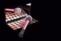 Makeup palets and brush on pure black background. Royalty Free Stock Photo
