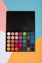 Makeup palette on a colorful geometrical background.