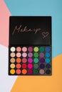 Makeup palette on a colorful geometrical background.