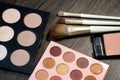 Makeup products and beauty brushes are placed on the table, including blush, eye shadow palette, highlighter powder Royalty Free Stock Photo