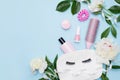 Makeup products with cosmetic bag and flowers on color blue background, copy space Royalty Free Stock Photo