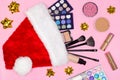 Makeup products with Santa hat and gift bows. Top view, flat lay. Make-up cosmetics as Christmas and New Year present Royalty Free Stock Photo