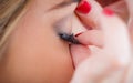 Makeup professional artist applying false eyelashes