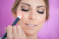 Makeup artist applying makeup on her face using powder brush Royalty Free Stock Photo