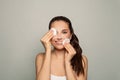 Makeup Remove. Cute brunette woman cleaning her face with cosmetic pads Royalty Free Stock Photo