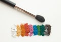 Makeup artist accessories for eyemakeup. Brush with crushed colorful eyeshadows on white background