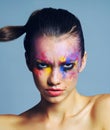 Makeup thats anything but meek. Studio shot of an attractive young woman with brightly colored makeup against a blue Royalty Free Stock Photo