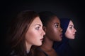 Makeup. Three women portrait. Caucasian and afro-american women posing in studio over black background