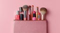 Makeup tools and cosmetics arranged in a pink cosmetic pouch on a pastel background Royalty Free Stock Photo