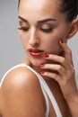 Makeup, woman for beauty and manicure in studio, nail polish and lashes with skin and cosmetics on grey background. Red