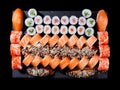 Maki ands rolls with tuna, salmon, shrimp, crab and avocado are served on stone slate.