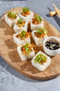 Maki roll with fried carrot and green onion top on wooden board in contemporary composition. Sushi roll with chopsticks on