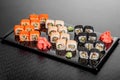 Maki Sushi set on dark pattern background. Sushi Set nigiri, rolls and sashimi served in black square plate Royalty Free Stock Photo