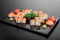 Maki Sushi set on dark pattern background. Sushi Set nigiri, rolls and sashimi served in black square plate Royalty Free Stock Photo