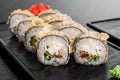 Maki Sushi set on dark pattern background. Sushi Set nigiri, rolls and sashimi served in black square plate Royalty Free Stock Photo