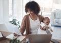 Making the balancing act look like a breeze. a young woman using a laptop while caring for her adorable baby girl at Royalty Free Stock Photo