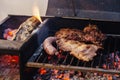 Making a barbecue with a portbale grill on the balcony. Traditional roast beef of Argentina. Argentinian Asado Royalty Free Stock Photo