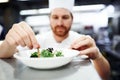 Making beautiful food. a chef putting the final touches on a dinner plate in a professional kitchen. Royalty Free Stock Photo