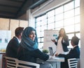 Making big moves in the boardroom. Portrait of a smiling arab businesswoman attending a presentation with her colleagues Royalty Free Stock Photo