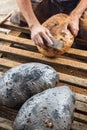 Making bread the traditional way - cleaning away the charred crust