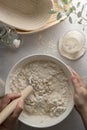 Making bread wheat with sourdough starter. Homemade breadmaking, female hand over white bowl cooking bread. Royalty Free Stock Photo