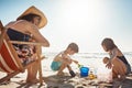 Making buckets full of memories. an adorable little boy and girl playing with beach toys in the sand while their mother Royalty Free Stock Photo