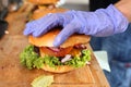 Making burgers. Preparing a hamburger in a protective gloves, in a food truck, in a fast food restaurant, close up.